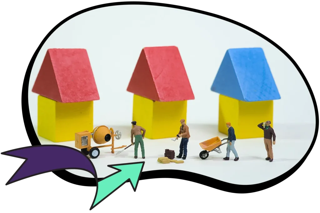 Model houses being built by workers with a cement mixer and wheelbarrow